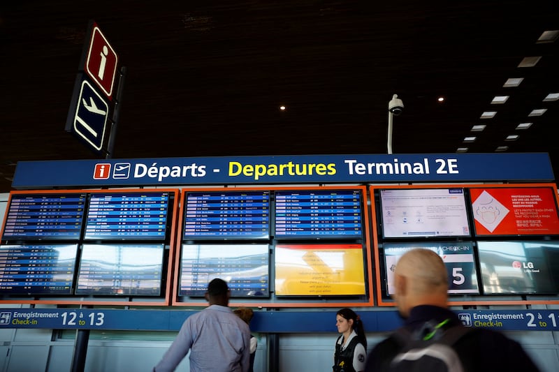 Passengers look at departure boards at Charles de Gaulle airport in Paris. Reuters