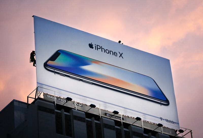 (FILES) In this file photo taken on November 3, 2017, workers finish putting up a new iPhone X billboard above Union Square in advance of the iPhone X launch in San Francisco, California.
Apple said on July 31, 2018, that its profit had jumped to $11.5 billion in the recently ended quarter, besting market expectations despite selling fewer iPhones than analysts projected. Revenue in the quarter soared 17 percent to $53.3 billion from the same period a year earlier on the back of sales of iPhones, online services, and wearable devices.
 / AFP PHOTO / Elijah Nouvelage