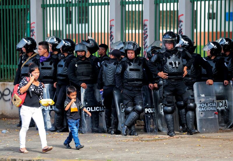 A woman and her son walk past a line of riot police during a protest against Nicaraguan President Daniel Ortega's government in Managua. Oswaldo Rivas/Reuters