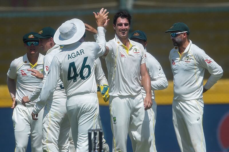Australia's captain Pat Cummins celebrates with teammates dismissing Pakistan's Fawad Alam. AFP