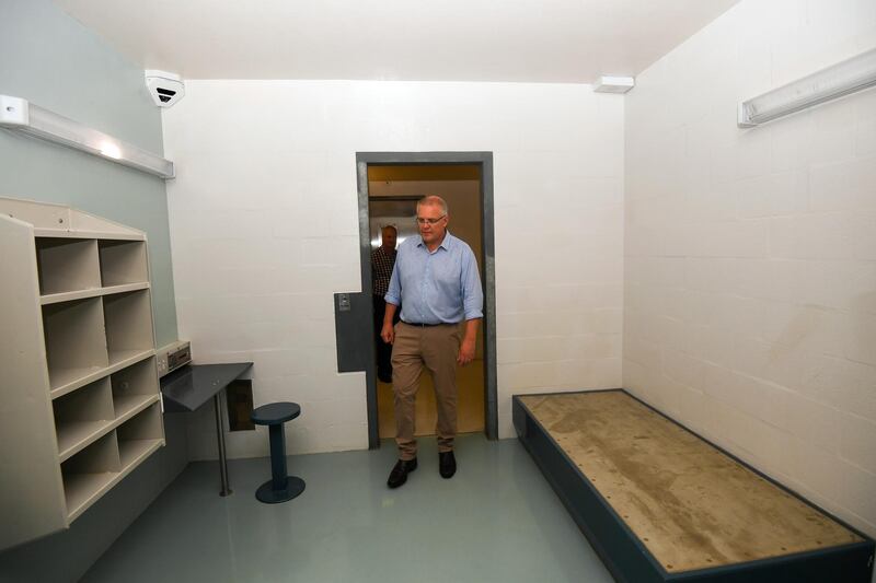 In this March 6, 2019, photo, Australian Prime Minister Scott Morrison walks into a high care accommodation room as he tours the North West Point Detention Centre on Christmas Island. Australia's government on Thursday, Jan. 30, 2020, defended its plan to send citizens evacuated from the epicenter of China's novel coronavirus emergency to the remote island used to banish asylum seekers and convicted criminals, despite warnings that that some Australians would prefer to stay in China. (Lukas Coch/AAP Image via AP)