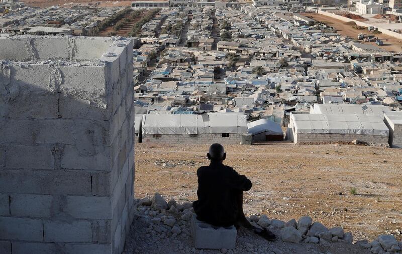 An elderly Syrian sits overlooking Atmah IDP camp located near his country's border with Turkey. Reuters