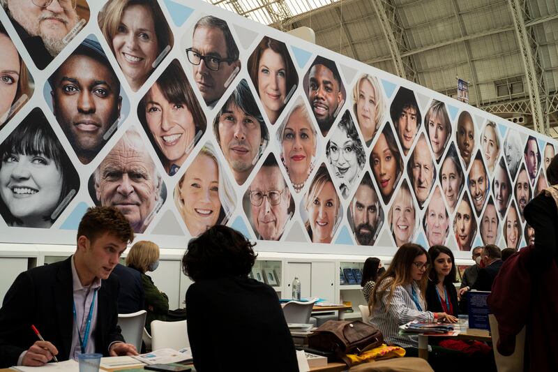 Harper Collins authors on display above members of the book trade attending London Book Fair in the UK capital. Getty Images