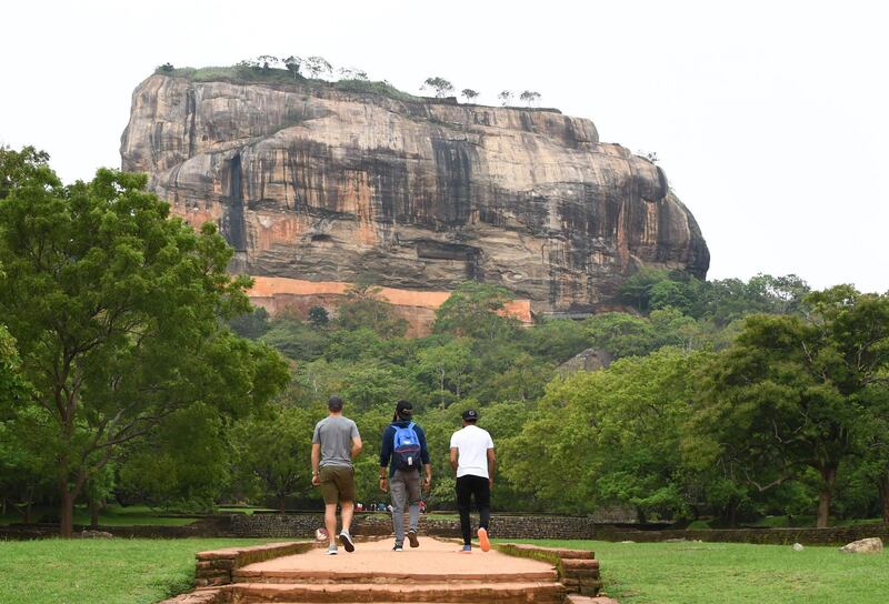 England cricketers Jos Buttler (L), Moeen Ali (C) and Adil Rashid (R) walk from the 80-metre ancient rock fortress of Sigiriya in north-central Sri Lanka. The Sigiriya rock, 160 kilometres north of Colombo, is a World Heritage site known for frescoes of bare-chested women. AFP