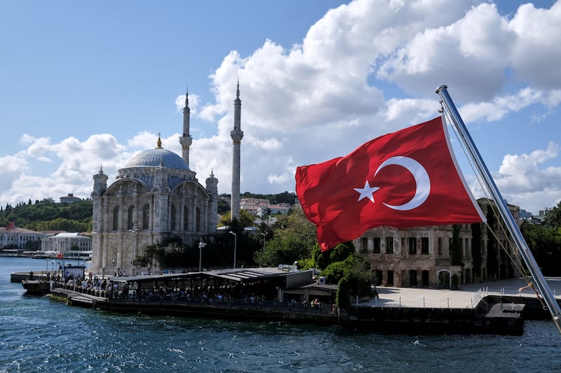 A Turkish flag is pictured on a boat with the Ortakoy Mosque in the background in Istanbul, 'Türkiye'. Reuters