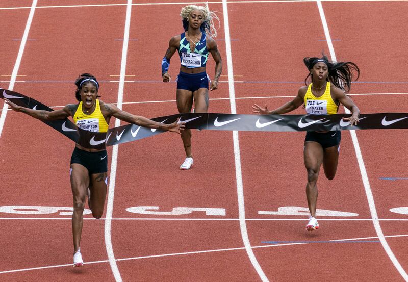 Jamaica's Elaine Thompson-Herah, left, wins the 100m, as American Sha'carri Richardson, centre, struggles. AP