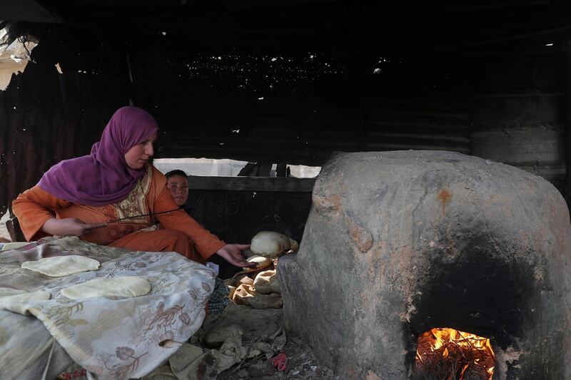 A Palestinian woman bakes bread on a clay oven in the northern Gaza Strip. Reuters