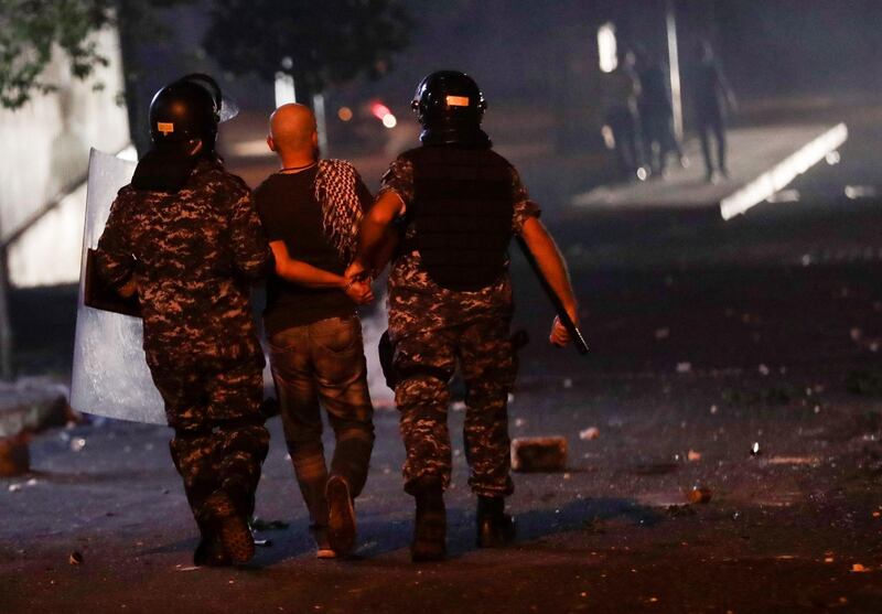 Lebanese security forces arrest a man during an anti-government demonstration against dire economic conditions in the downtown district of the capital Beirut. AFP