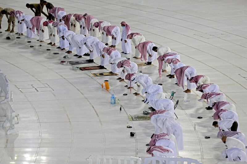 TOPSHOT - Worshipers perform Isha prayer while keeping distance between them next to the Kaaba in Mecca's Grand Mosque, Islam's holiest site on April 27, 2020. Saudi Authorities allowed for limit number of worshipers to enter the Grand mosque to perform prayers during the Islamic holy fasting month of Ramadan, amid unprecedented bans on family gatherings and mass prayers due to the coronavirus (COVID-19) pandemic. / AFP / STR
