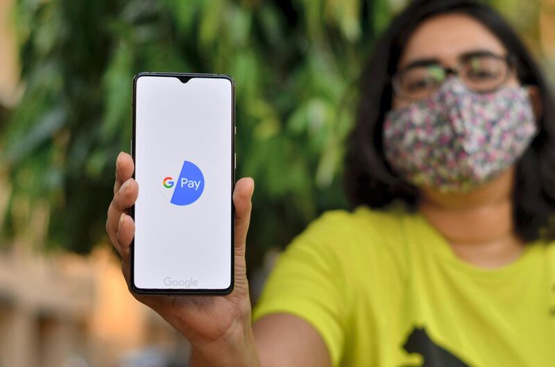 2BXFHRC New Delhi, India, 2020. Girl wearing a face mask showing Google Pay app during Corona Virus (Covid-19) disease pandemic. People are encouraged to not