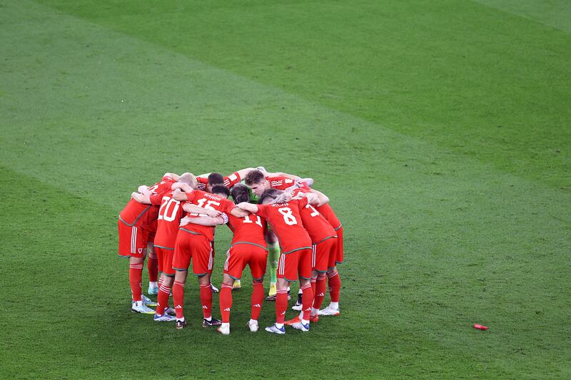 Wales players in a huddle prior to kick-off. Getty