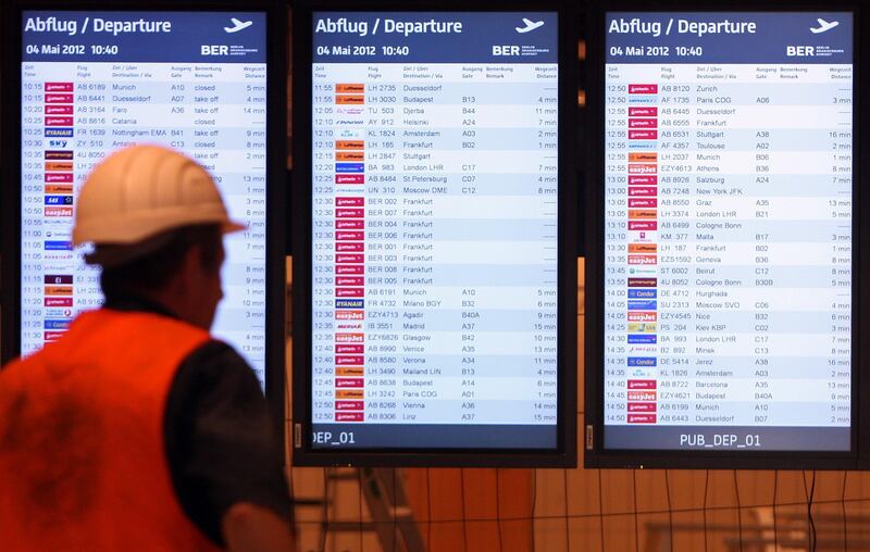 BERLIN, GERMANY - MAY 04:  A worker passes boards displaying flight information from nearby airports as a test to make sure they are running correctly in the departures area of Berlin Brandenburg Airport (IATA code BER) on May 4, 2012 in Schoenefeld, near Berlin, Germany. The new airport, located south of Berlin, is scheduled to open on June 3 and will replace three airports: Tempelhof Airport expanded by the Nazis which closed in 2008, Tegel Airport, scheduled to close later this year, and Schoenefeld Airport, which currently exists at the site of the new facility and was opened in 1934 to host an aircraft plant. The new airport, designed for a capacity of 27 million passengers a year, has cost nearly three billion euros to construct, controversial in a city that has one of the highest levels of unemployment in the country, at twice the German national average. Proponents of the new airport contend that the building may salvage the capital city which has struggled economically in recent years.  (Photo by Adam Berry/Getty Images)