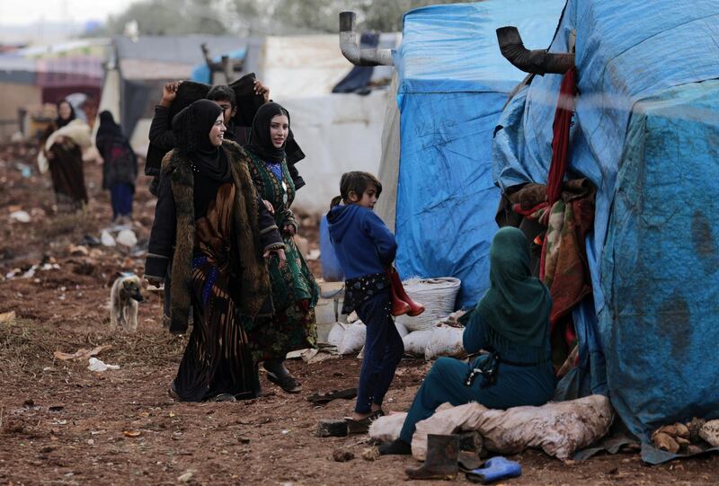 Internally displaced people stand outside tents at a makeshift camp in Azaz, Syria.  Reuters