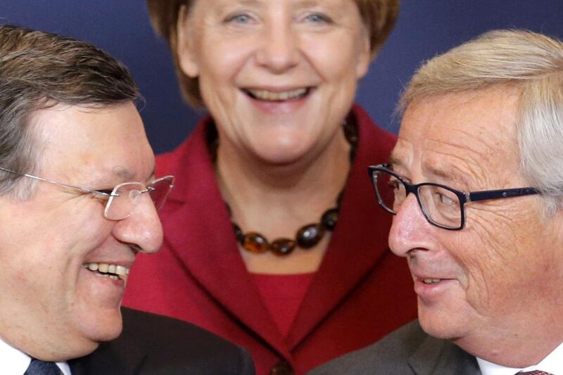 Germany's Chancellor Angela Merkel (centre) smiles as she poses for a family photo next to incoming president of the European Commission Jean-Claude Juncker (right) and outgoing president Jose Manuel Barroso during an EU summit in Brussels on October 23, 2014. European leaders aim to agree a new decade of energy policy to cut climate-warming gas emissions to 2030 at an EU summit on Thursday, but sharp differences over sharing the cost mean a deal will be difficult. Christian Hartmann / Reuters