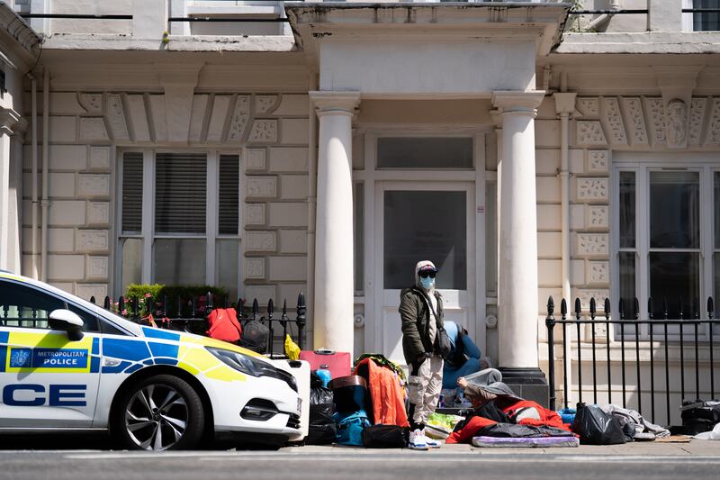 Photos taken at the scene show bedding laid out on cardboard and bags and suitcases.

