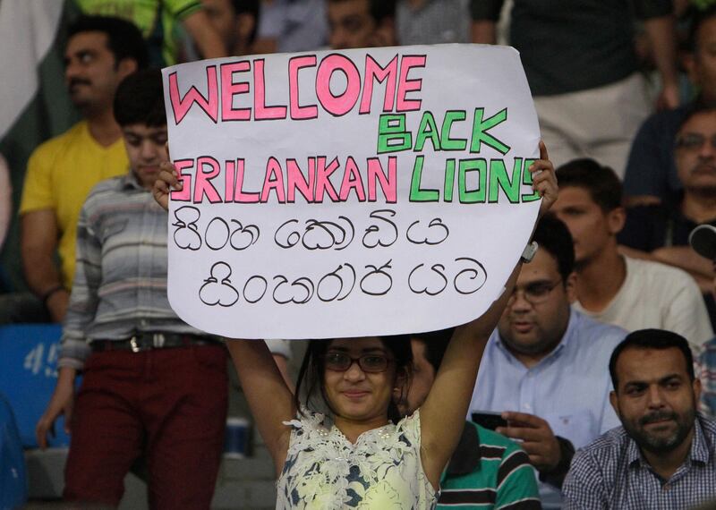 A cricket fan holds a placard welcoming the Sri Lankan team during the third Twenty20 international match between Pakistan and Sri Lanka at the Gaddafi stadium in Lahore, Pakistan, Sunday, Oct. 29, 2017. (AP Photo/K.M. Chaudary)