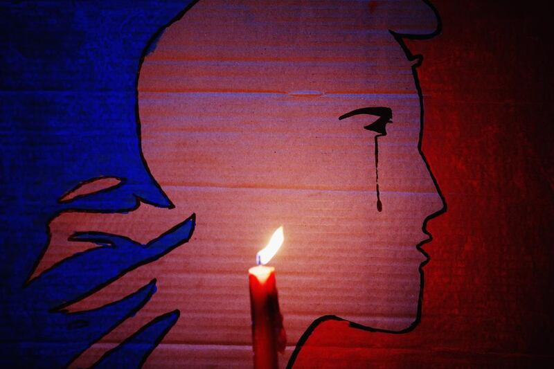 A candle burns in front of a Marianne with a tear during a vigil in Aotea Square, Auckland, New Zealand, on Novemebr 14, 2015, to remember the victims of the Paris attacks. Hannah Peters/Getty Images