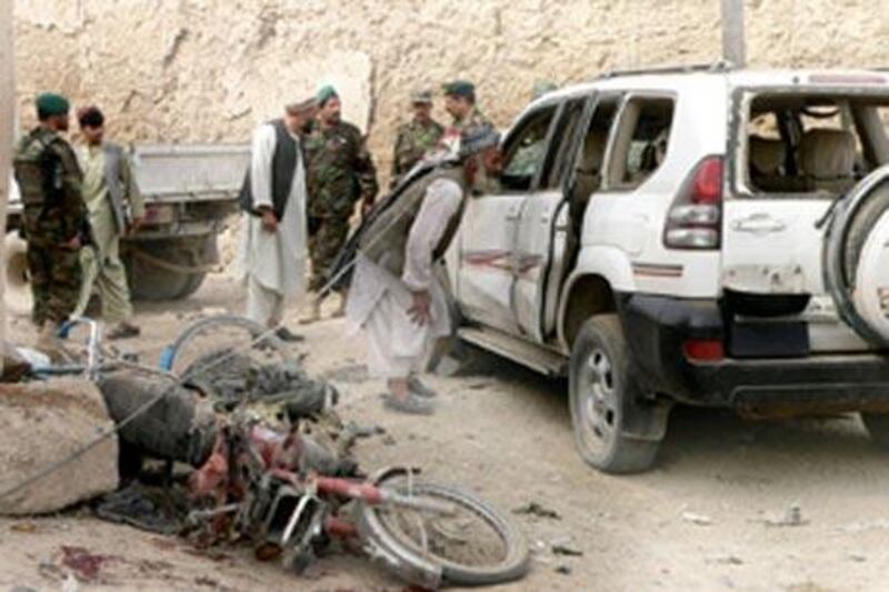 Afghan men walk around the site of an explosion in Kandahar city.