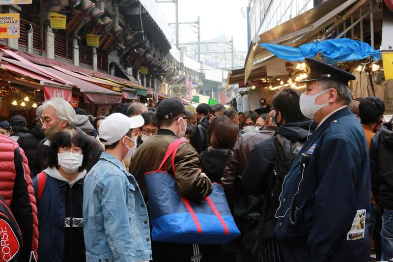 People wearing face masks to protect against the spread of the coronavirus visit the Ameyoko shopping street to purchase ingredients for New Year's dishes, in Tokyo. AP
