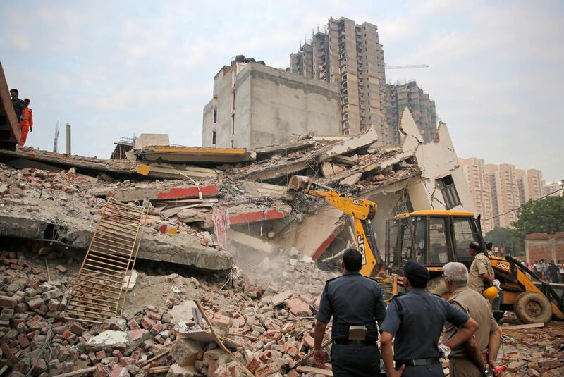 A backhoe is operated at the site of a collapsed building in Shahberi village. AP Photo