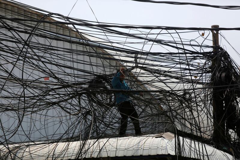 An electrician untangles electrical wires along a street in Phnom Penh, Cambodia. Samrang Pring / Reuters