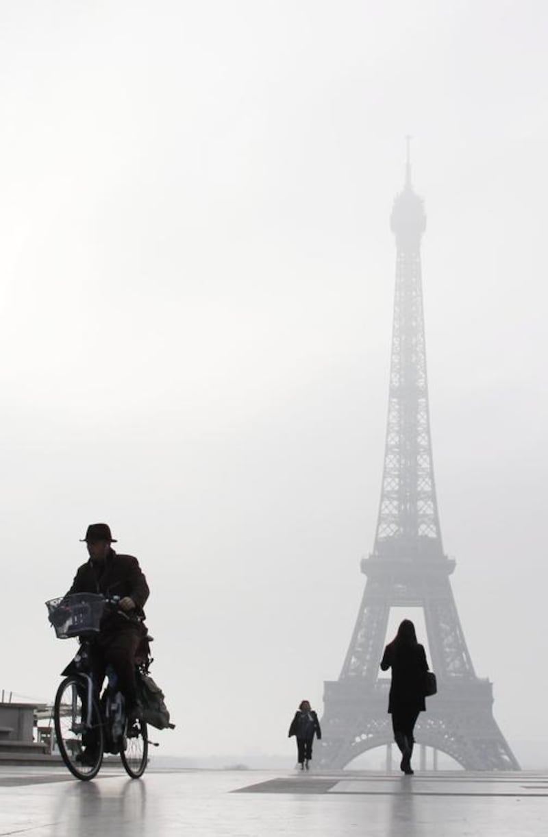 A man rides a bicycle on the Esplanade du Trocadero in front of the Eiffel tower, in Paris. Ludovic Marin / AFP