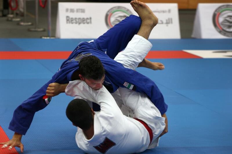 Abdulrahman Albarguthi (blue) rumbles on the mat with his opponent during their 77kg match. Delores Johnson / The National