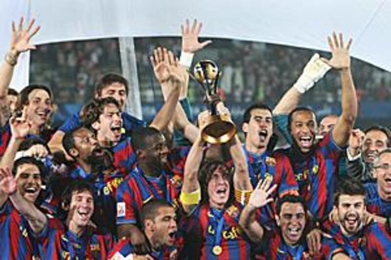 Carlos Puyol lifts the Club World Cup with his Barca teammates.