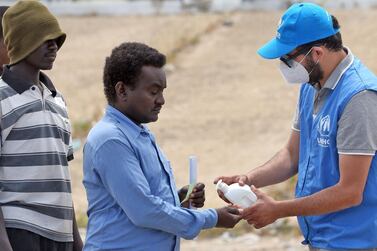 A man sanitises his hands to protect against the coronavirus before collecting aid at a United Nations camp for displaced Libyans and asylum seekers. AFP