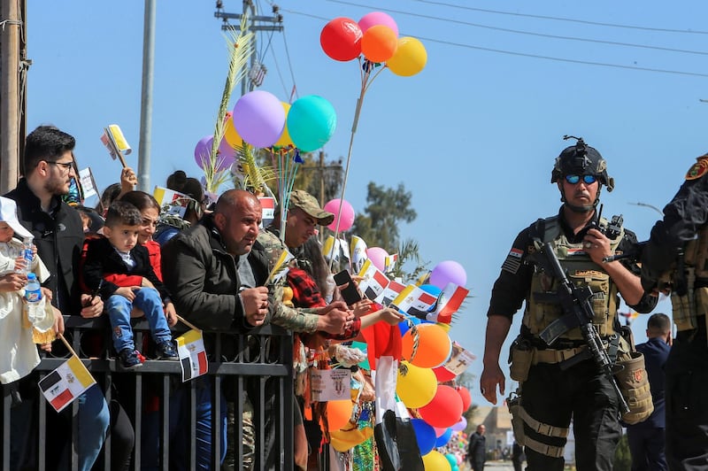 An Iraqi security force officer guards as people wait to greet Pope Francis in the town of Qaraqosh. Reuters