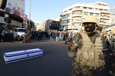 An Iranian soldier stands near a mock coffin that is draped in an Israeli flag during a pro-Palestinian protest in Tehran on Wednesday. Iran is the only state in the world publicly committed to the destruction of Israel. AFP