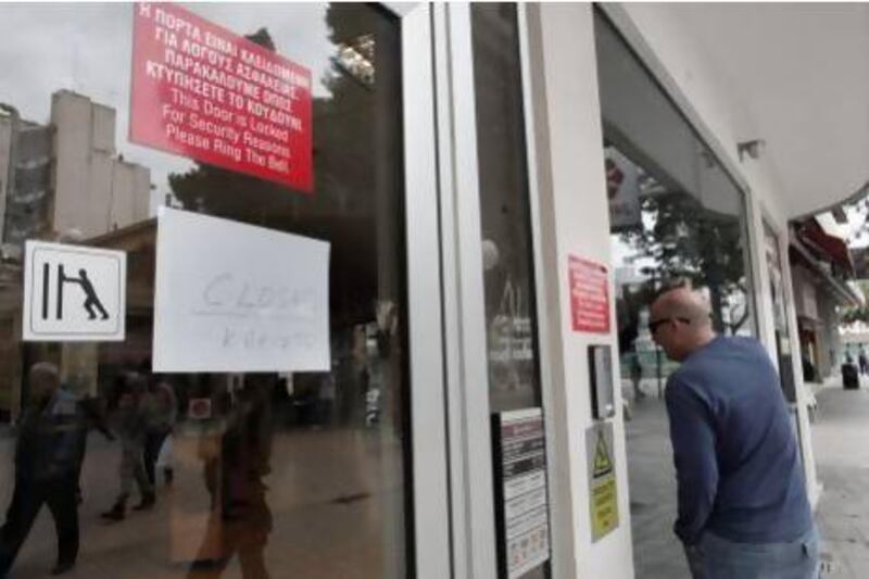 A man looks inside a closed Laiki Bank branch in the Cyprus capital, Nicosia. Cypriot banks will be closed until Thursday to prevent a further run on deposits.