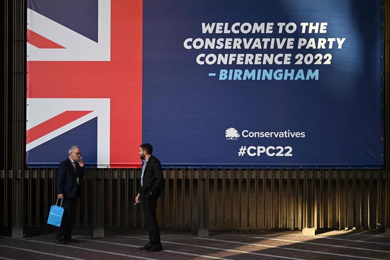 Delegates take a break outside the venue on the opening day. AFP