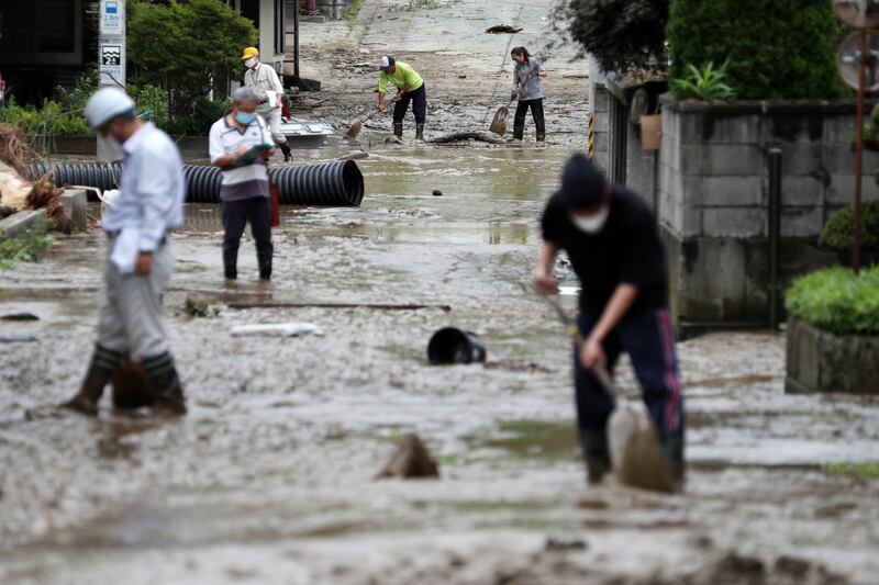 Residents clean a street covered with mud following floods in Oe city, in north-eastern Japan, on August 4, 2022. Large areas of north-eastern and central Japan were hit by torrential rainfall, and more than 100,000 residents were asked to evacuate. EPA