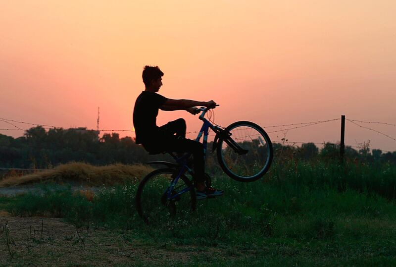 Mustafa Abdullah enjoys a ride on his bicycle at sunset near the bank of the Tigris River in Baghdad, Iraq. AP Photo