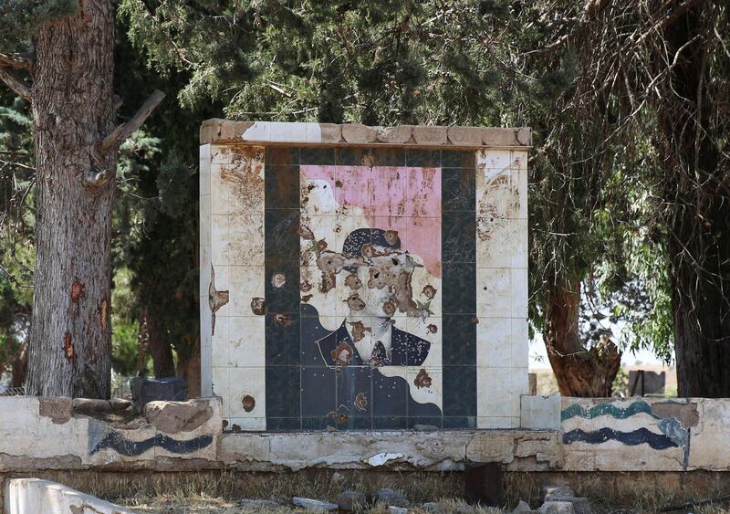 A damaged picture of Syrian president Bashar Al-Assad is seen on a wall in Quneitra, Syria July 8, 2017. REUTERS/Alaa al-Faqir