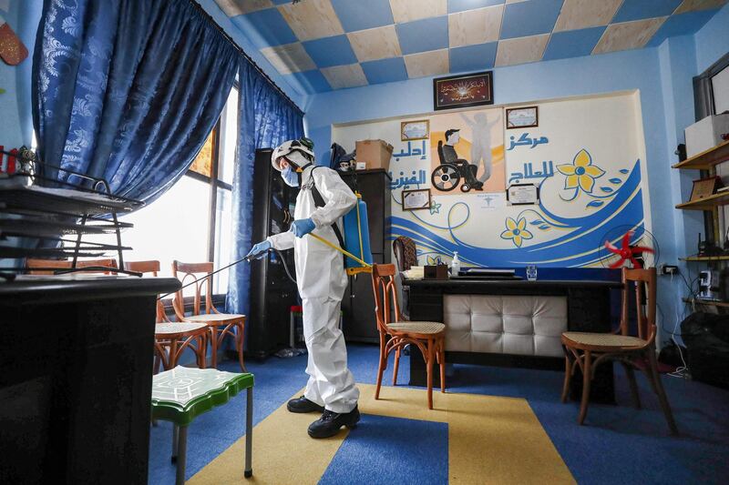 A member of the Syrian Civil Defence, also known as the 'White Helmets' disinfects a room at a physiotherapy centre in Syria's rebel-held northwest city of Idlib.  AFP