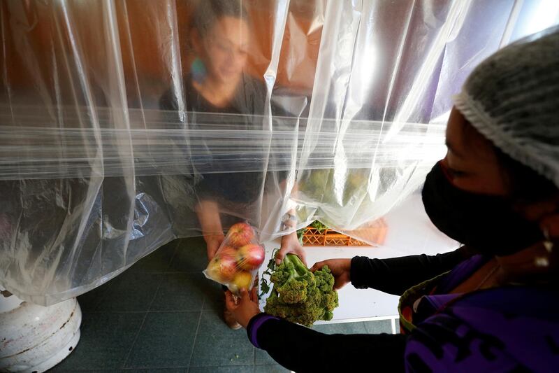 A volunteer delivers food rations at a so-called 'Olla comun', a communal kitchen set up to provide hot food for those with dwindling incomes or nothing, on a hill named "Mariposas" (butterflies), during the spread of the coronavirus disease (COVID-19), in Valparaiso, Chile. REUTERS
