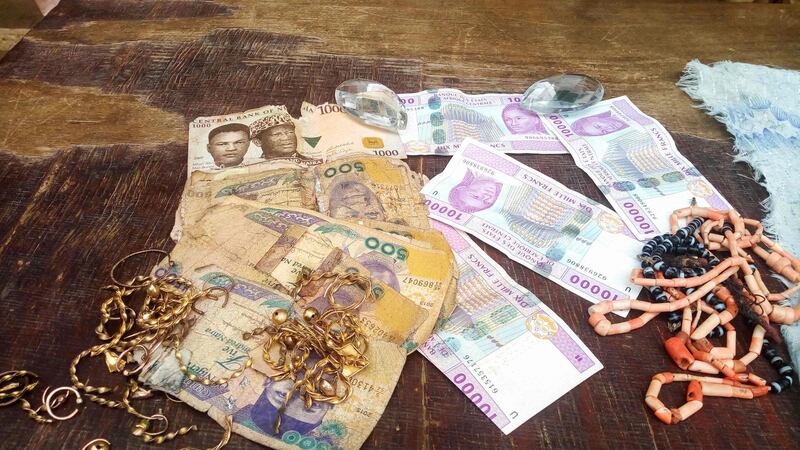 A picture shows jewellery items and banknotes recovered from suspected Boko Haram militants, displayed by the police, in Maiduguri, northeast Nigeria, on July 18, 2018. Eight men have been arrested in connection with Boko Haram's abduction of more than 200 schoolgirls from the remote town of Chibok in northeast Nigeria, police said on July 18, 2018. The 14 others were alleged to have been involved in logistics and planning suicide bomb attacks.  / AFP / AUDU MARTE
