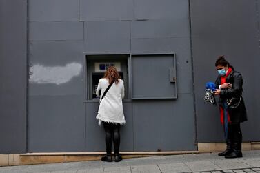 A woman withdraws money from an ATM machine at the entrance of a bank in Beirut on December 01, 2020. Lebanon's economy is sinking into a 'deliberate depression', the World Bank said citing the authorities' failure to tackle the crisis. AFP