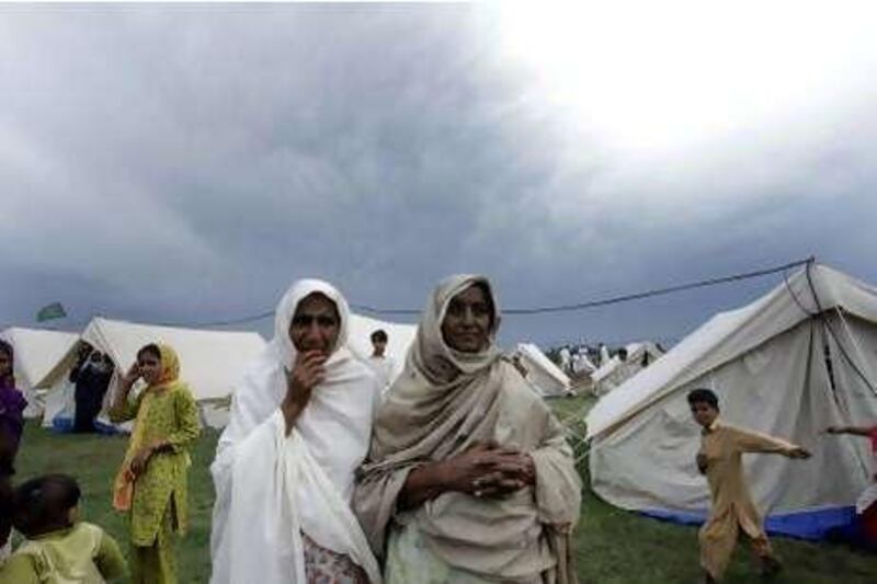 Pakistani women who survive floods wait  for a relief supply in a camp setup for displaced people in Pubbi, near Peshawar, Pakistan on Friday, Sept. 17, 2010. Millions of people are affected and displaced by heavy flooding in Pakistan. (AP Photo/Mohammad Sajjad *** Local Caption ***  PES101_Pakistan_Floods.jpg