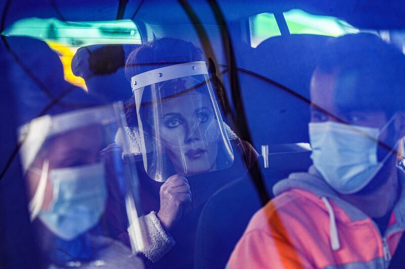 Marisol Aro, wearing a face shield with an image of Wonder Woman, looks out from a car, amid the new coronavirus pandemic in Santiago, Chile, Saturday, June 27, 2020. Aro's husband bought her the face shield who has since been infected with the new coronavirus and is now intubated in an intensive care unit. (AP Photo/Esteban Felix)