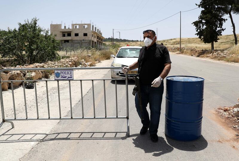 Palestinian security forces guard a checkpoint at an access road in the village of Beit Aula, north of the West Bank city of Hebron.  EPA