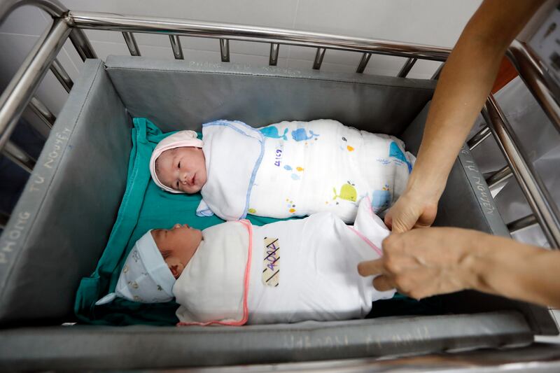 A nurse cares for newborn babies at a hospital in Hanoi, Vietnam. EPA