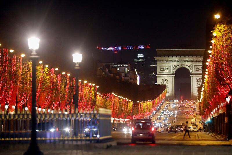 Christmas holiday lights decorate trees along the Champs Elysees in Paris with the Arc de Triomphe in the background, France, November 22, 2020. REUTERS/Charles Platiau