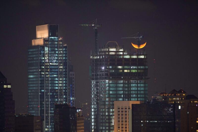 A crescent moon sits behind a high-rise building under construction in Jakarta. Indonesian GDP growth was pegged 5.21 per cent in the first quarter, its slowest pace since late 2009 as weak exports and tight monetary policy weighed on Southeast Asia’s top economy. Romeo Gacad / AFP