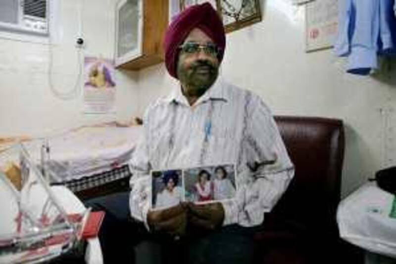 RAS Al KHAIMAH - NOVEMBER 25,2009 - Menjit Singh Reehal holds the pictures of his family during photo shoot at his room in Ras Al Khaimah. ( Paulo Vecina/The National ) *** Local Caption ***  PV Manjeet 8.jpg