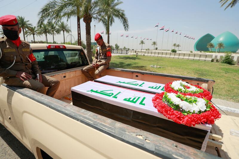 Iraqi military vehicles carry coffins of the dead on Tuesday. AFP
