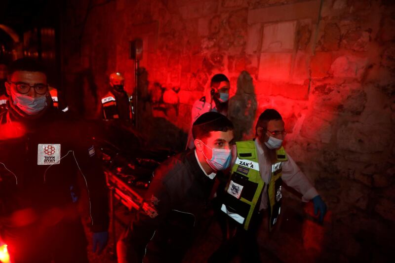 Israeli rescue workers carry the body of a Palestinian near the scene of an attack in the Old City of Jerusalem, Monday, Dec. 21, 2020. Israeli police said Monday they shot a Palestinian attacker who opened fire at a group of officers in Jerusalem's Old City. (AP Photo/Mahmoud Illean)