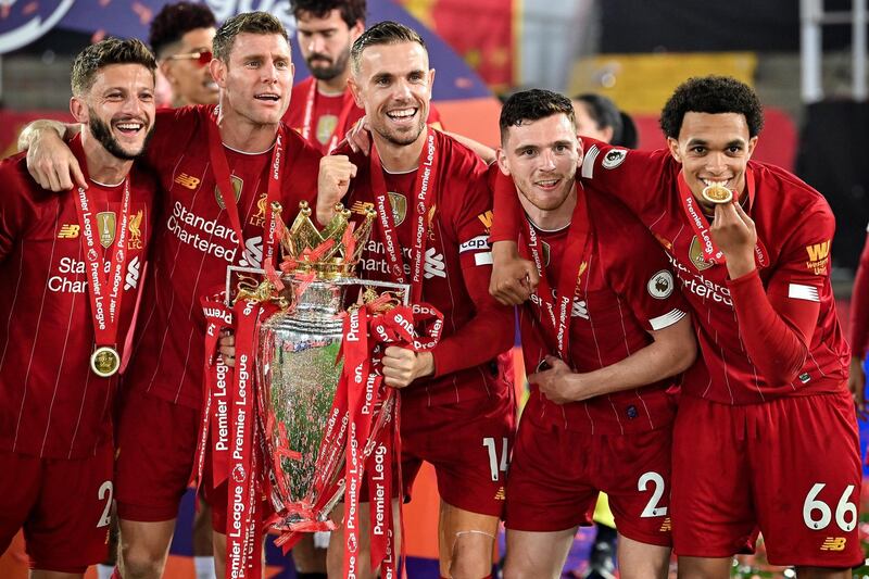 Liverpool players pose with the trophy. EPA